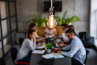 Young business people are discussing together a new startup project. A glowing light bulb 