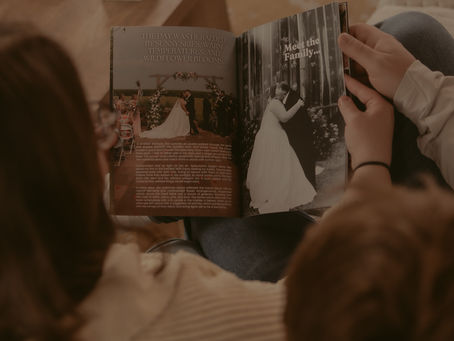 A married couple reviews their custom wedding magazine by Preserved in Print to preserve their wedding memories.