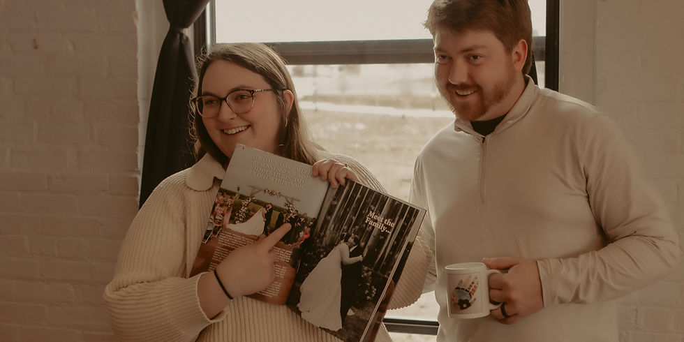 A married couple holds up their custom wedding magazine created by wedding journalist Preserved in Print to preserve wedding memories.