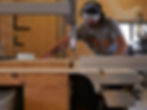 Artisan menuisier qui cie une planche en bois dans l'atelier