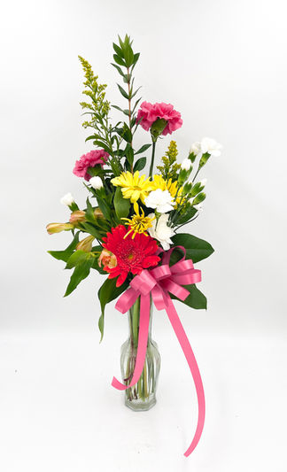 Mixed bud vase with a hot pink gerbera daisy and carnations, yellow alstroemeria and daisy poms, white mini carnations, solidago filler as an accent, with mixed greenery.