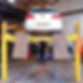 white hatchback raised up on an MOT ramp