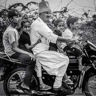 All the kids, even the unwilling ones are out for a ride. The rider wears a ‘kediyu and chorno’. Made from white cotton, this top and pleated pant set is the everyday preferred outfit for most men in rural Gujarat. 
