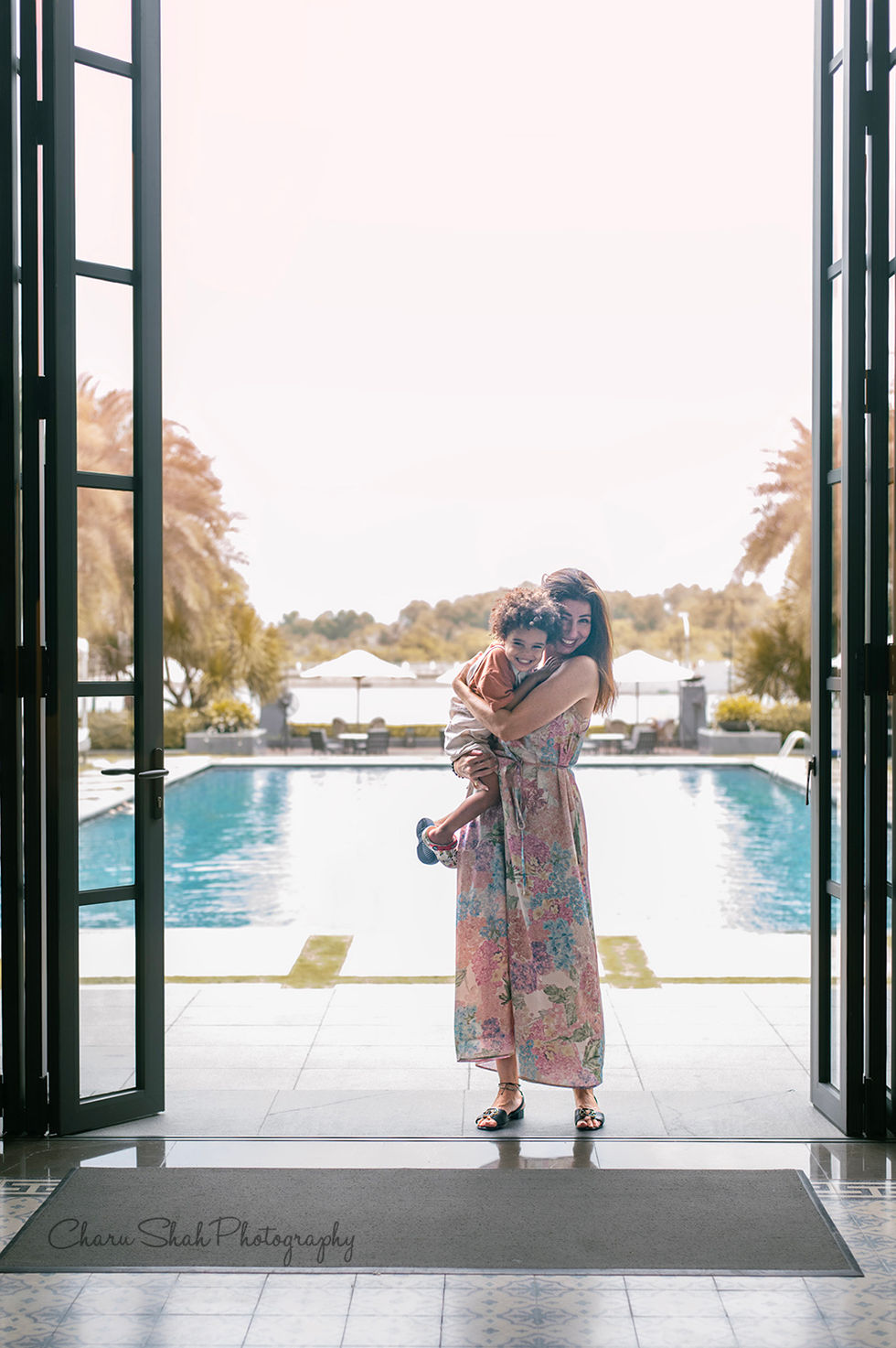 Mother standing and carrying her son and both are laughing