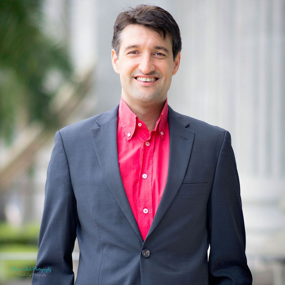 Portrait of a man in red shirt standing outside the National Gallery straight and smiling at the camera