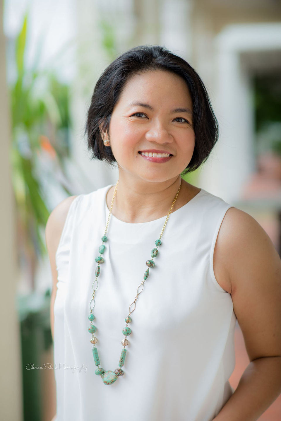 Outdoor photo of a lady wearing a white top with shallow depth of field 