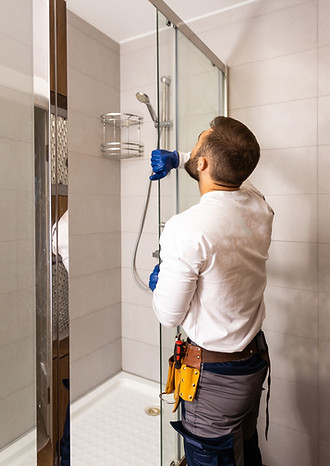Plumber installing a shower cabin in bathroom.jpg