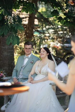 Hannah and Jonas listening during their outdoor celebration