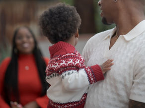 African American Father and Child looking back at a blurred image of the wife and mother.