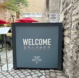 A sign reading Welcome in both English and ASL spelling