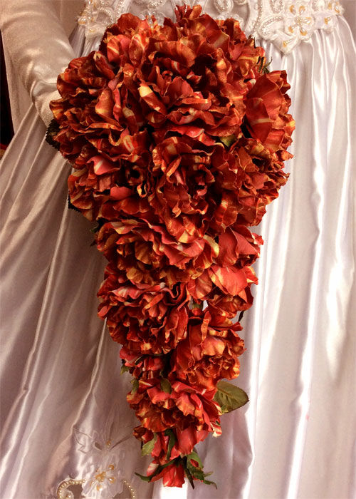 サムネイル： 金色に色づいた赤いバラのキャスケードブーケ