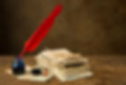 A red quill ped with a bundle of old love letters sitting on a worn wood desk