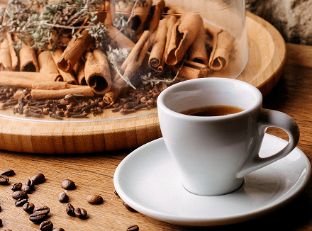 front-view-cup-coffee-along-with-coffee-seeds-cinnamon-bright-desk 1.png