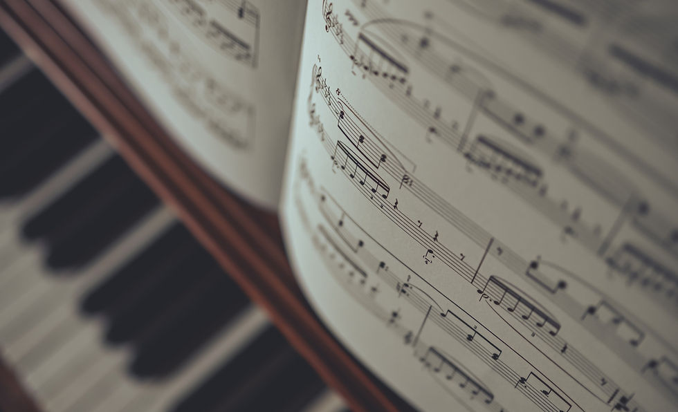 person improvising while playing an upright piano keyboard