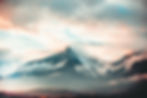 Dramatic mountain peak rising through clouds, natural landscape scenery and beauty.
