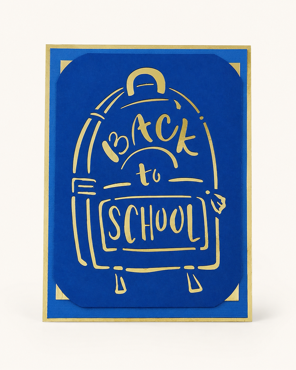 The image is a blue greeting card with a gold border, featuring a stylised illustration of a backpack 