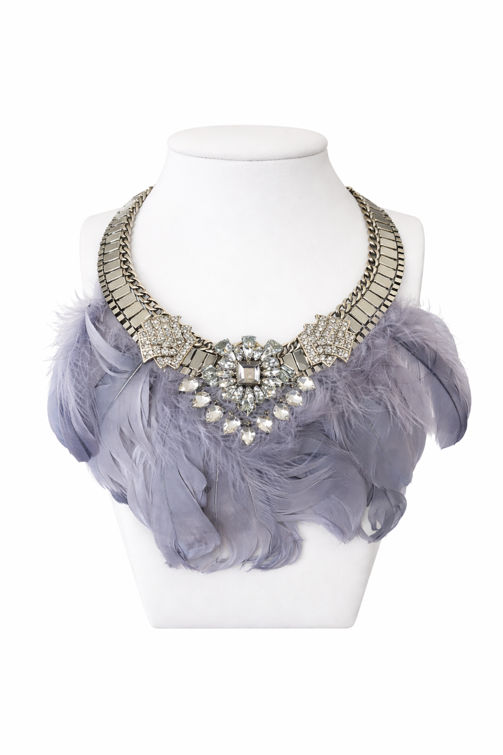 Monroe feather statement necklace with crystal centerpiece and silver collar design on white leather jewelry stand