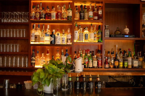 Interior view of a bar featuring counter seating and ambient lighting.