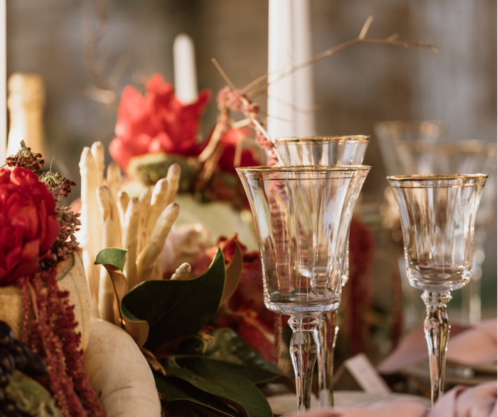 Hatzi Mansion, table de luxe avec bougies romantiques, art de la table en argent et assiette à bord doré. Décoration florale et végétale luxueuse sur la Riviera athénienne par Everly Luxury Events, agence Everly, organisatrice de mariages de luxe. Décoration innovante avec vue sur la mer. Verre en cristal à bord doré.