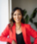A portrait photo of Tanie Hotan, smiling and wearing a red jacket. 
