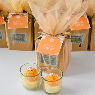 Gift boxes with orange personalized tags and two laddoo candles