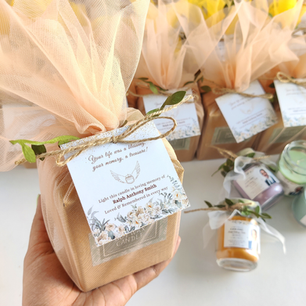 Hand holding a peach tulle-wrapped memorial return gift with a remembrance poem tag, in loving memory of Ralph Anthony Smith