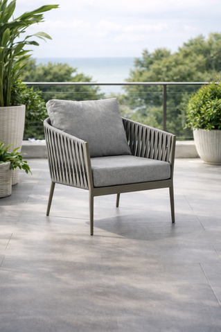 Modern gray outdoor armchair on a contemporary balcony patio overlooking trees.