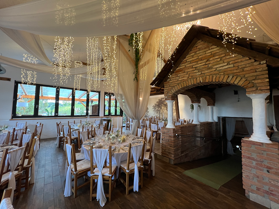 Der Hochzeitssaal mit Holzverkleidung, Lichterketten und weißen Tüchern