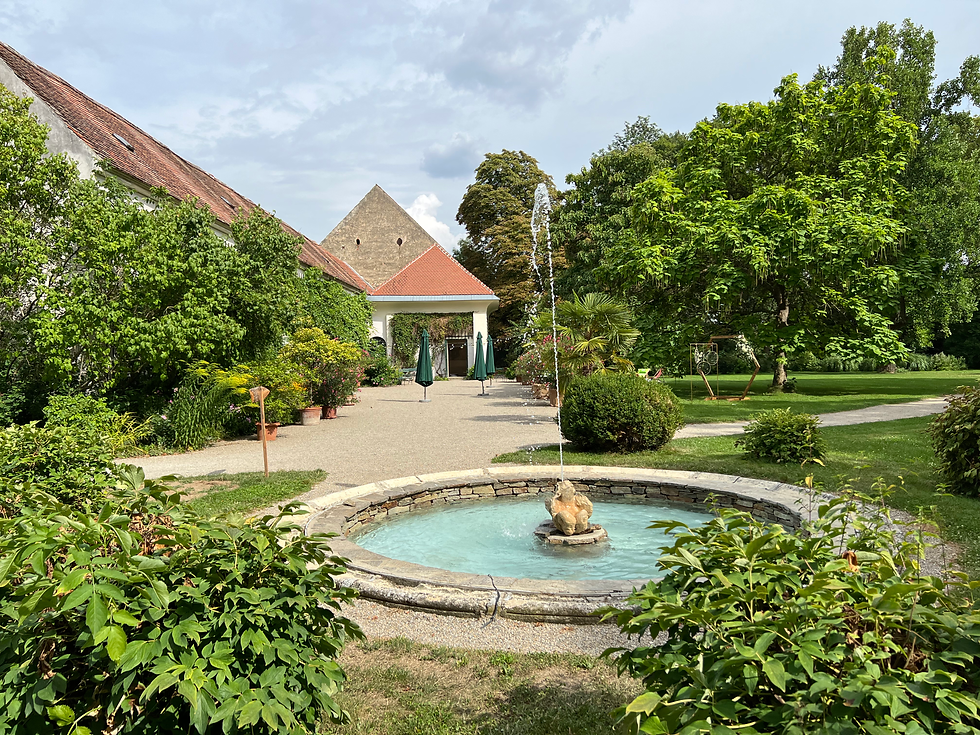 Parkanlage vor der Orangerie des Schloss Mühlbach mit Springbrunnen