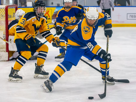 A Pittsburgh Panthers hockey player handles the puck during a game against the West Virginia Mountaineers.
