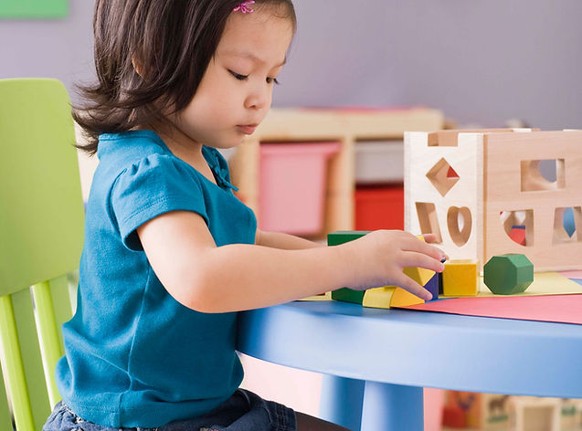 Toddler at preschool playing with a shape sorter