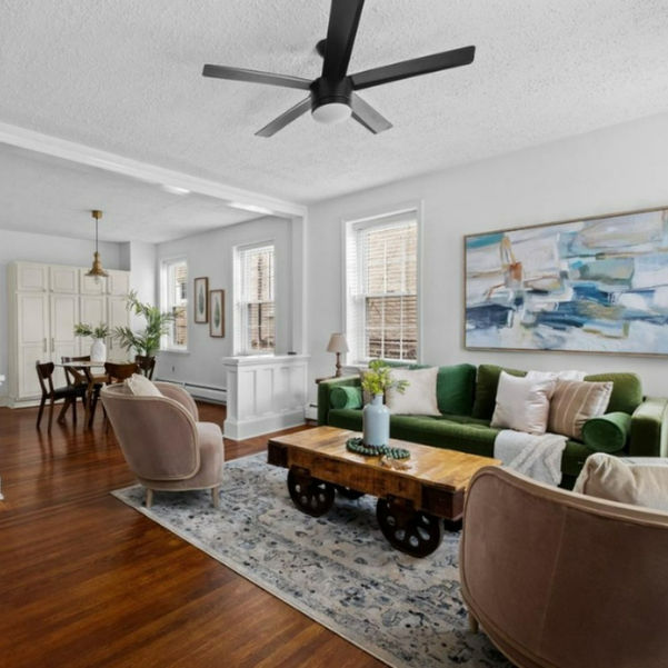 Living room in pinks, greens, and blue tones with rustic coffee table