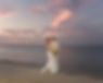 Bride and groom embracing on beach at sunset