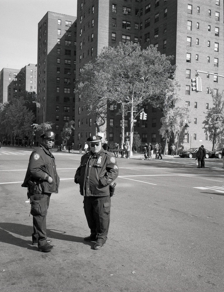 photographie en noir et blanc argentique, vintage. Deux policiers en faction à Harlem à New York pendant le marathon de New York. Obama 2008