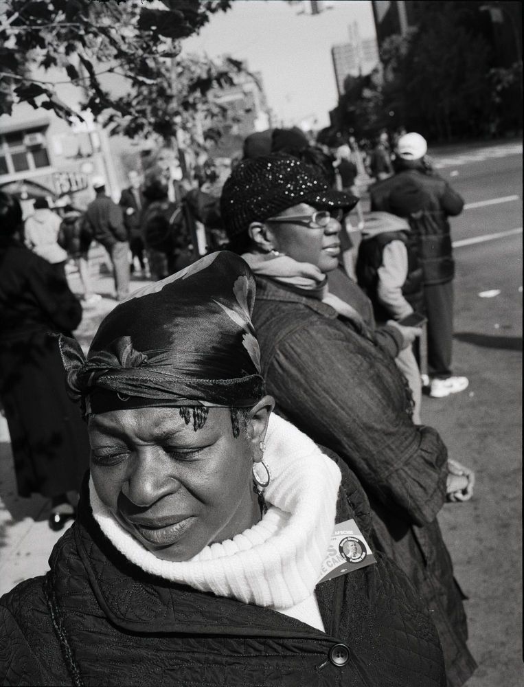 photographie en noir et blanc argentique, vintage. Une femme noir en gros plan dans une rue de Harlem à New York, pendant le marathon. Obama 2008
