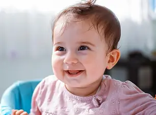 Baby lacht zufrieden in Kamera