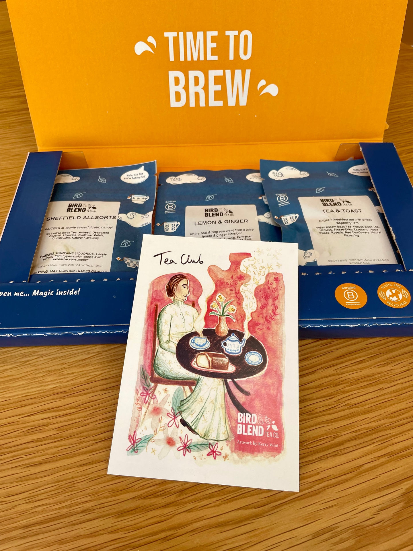 A selection of Bird and Blend Tea Company teas in their pouches with the drawing propped against them.