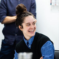 Smiling woman in a blue striped shirt. Happy face, bun hairstyle. women in tech uk