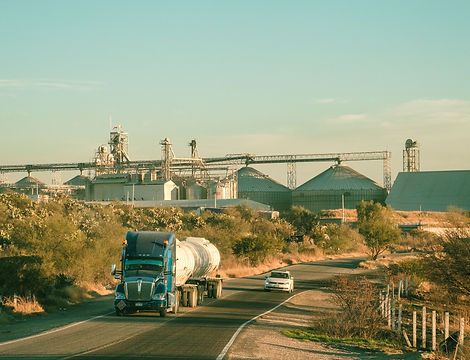Tanker truck on a highway near grain silos