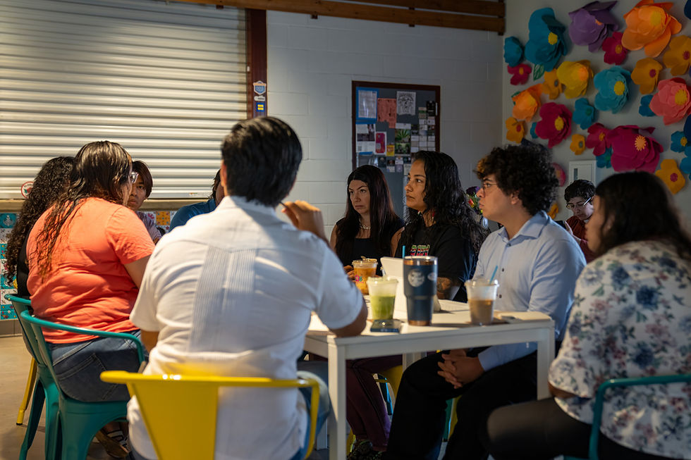A group of four people in a semi-circle having a conversation at Gloria's meeting