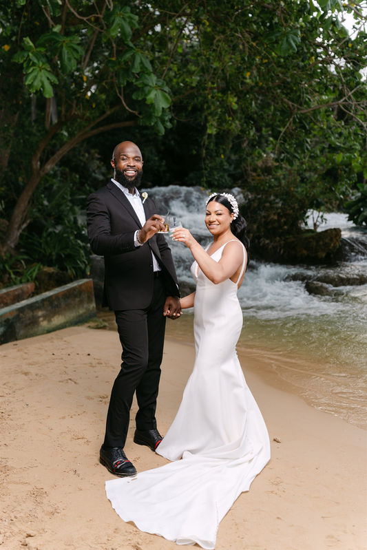 Couple on the beach beside a waterfall