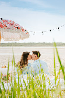 Warm pink luxury proposal picnic on the beach in Noosa
