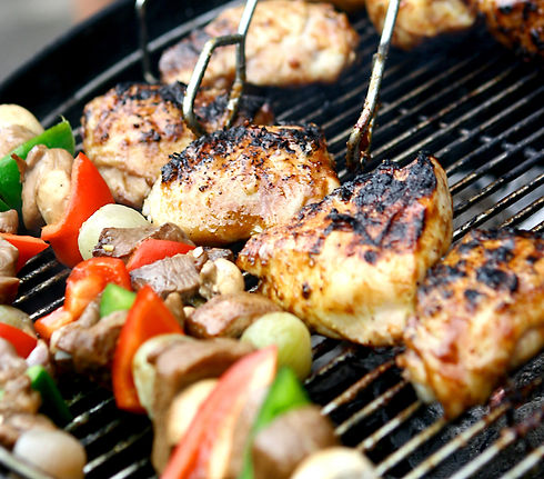 Sizzling chicken and sausages with lamb kebabs and vegetables on hot barbecue grill_edited