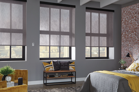 Modern living space featuring Graber roller shades, yellow sofa, and contemporary decor from Lumen Shade Solutions.