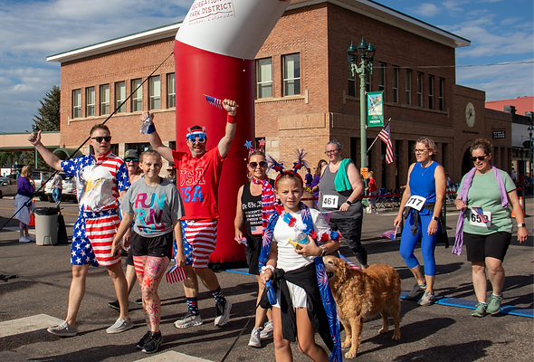 Race participants decked out in patriotic gear cross the finish line at the 2025 Run For Your Life 5K.