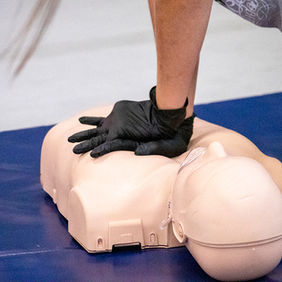 CPR training with hands pressing on a mannequin