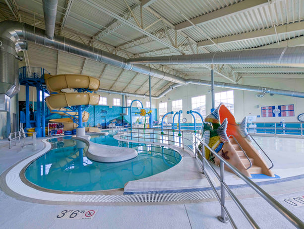 Indoor waterpark with slides and a curved swimming pool