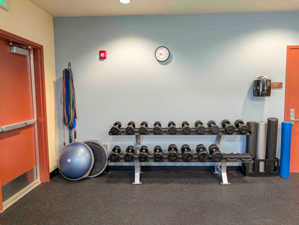 Dumbbell rack with weights and fitness equipment at Meeker Rec Center.