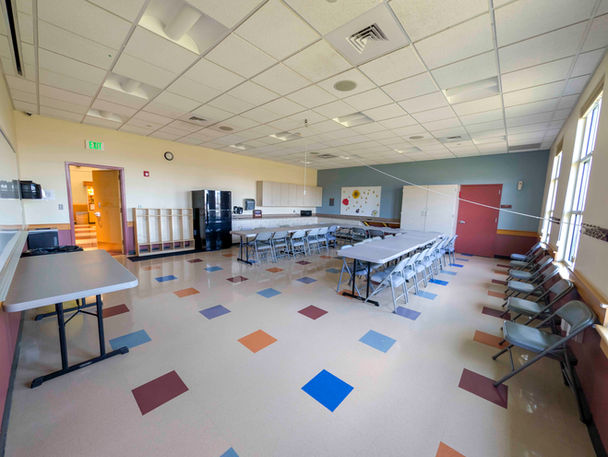 Meeker Rec Center multipurpose room with tables, chairs, and colored floor tiles.