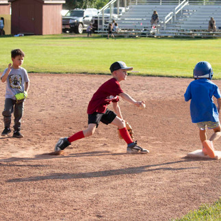 Three boys playing baseball on a field